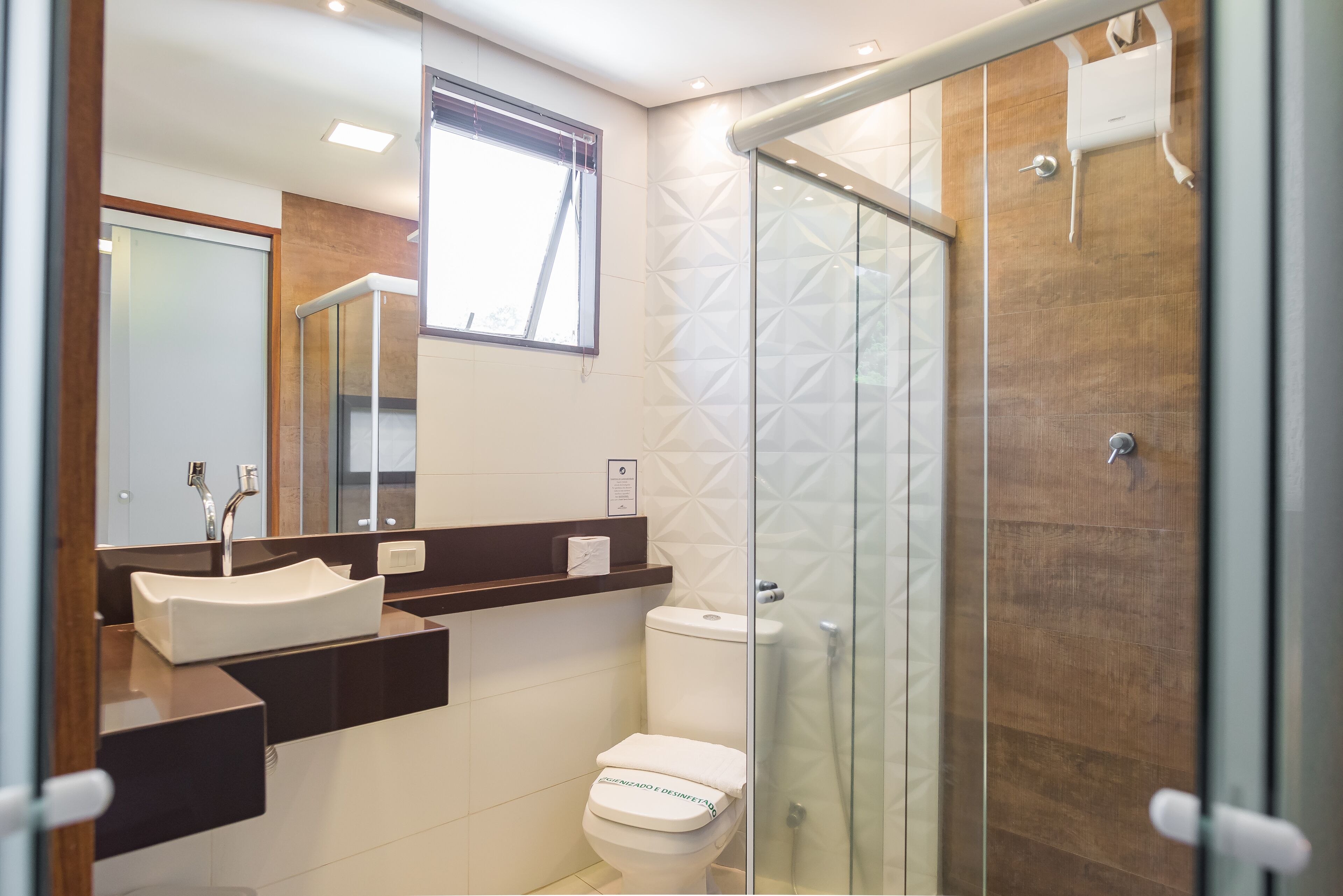 A modern bathroom with a glass shower enclosure, a white toilet, and a vanity with a sink.