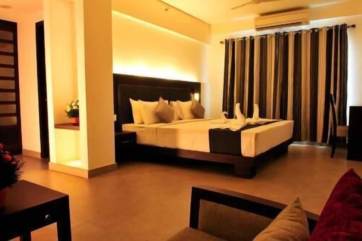 A modern hotel room with a large bed, bedside tables, and a view of the outdoors.