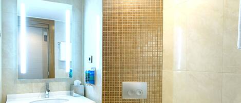 A modern bathroom with a sink, mirror, and toilet.
