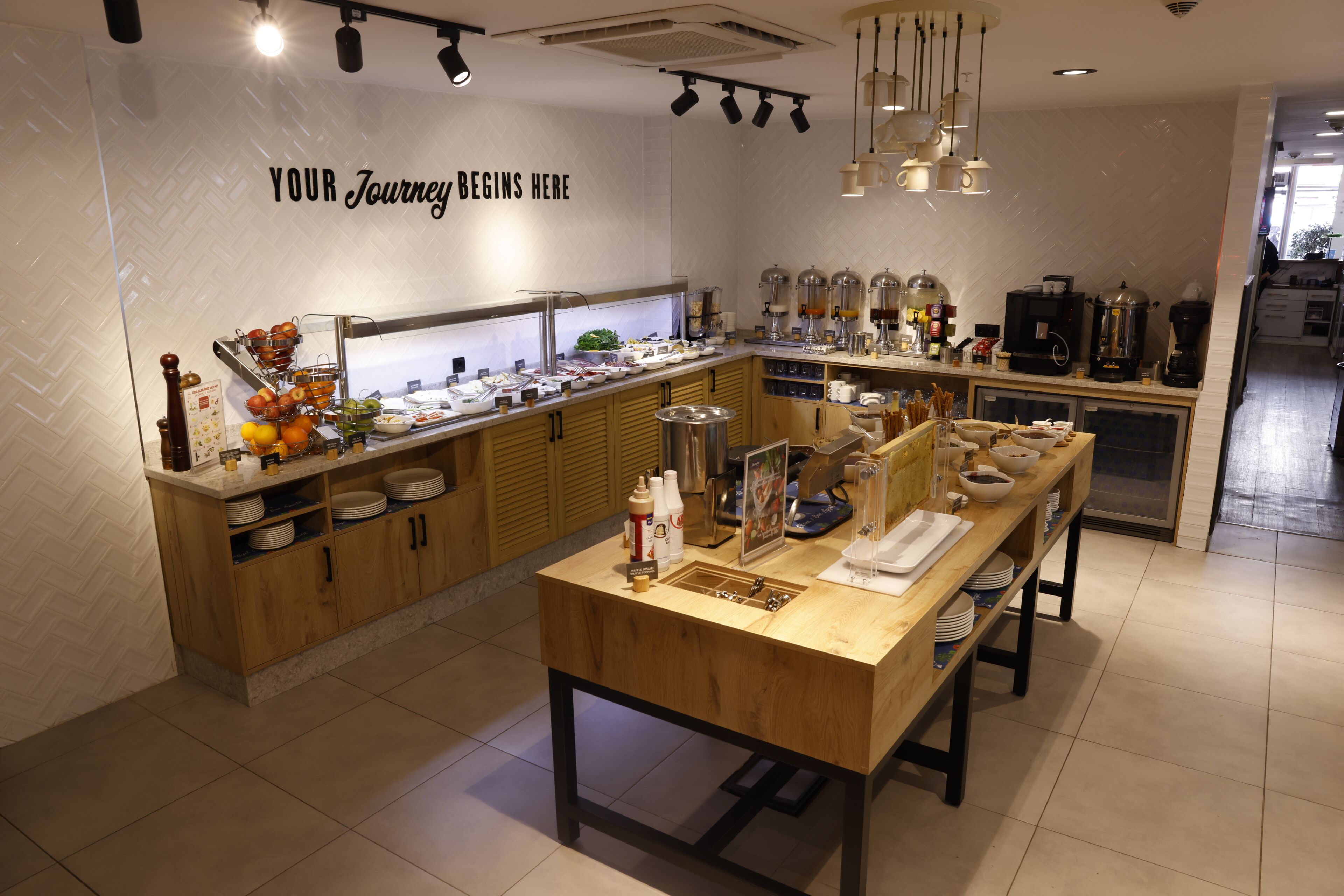 A breakfast bar with a variety of food items and a coffee station.