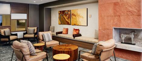 A modern lobby with leather sofas, a wooden coffee table, and artwork on the wall.