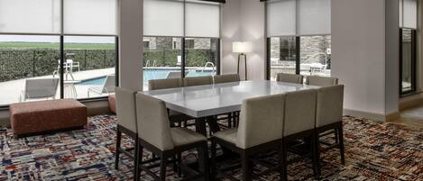 Un comedor moderno con una mesa grande, sillas y una alfombra estampada.