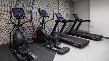 A gym with treadmills, elliptical machines, and stationary bikes.