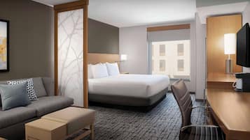 Une chambre d’hôtel avec un lit, un canapé, un bureau et une chaise.
