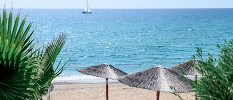 Aan het strand, ligstoelen aan het strand, parasols, een strandbar