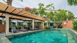 A swimming pool with lounge chairs and a pergola structure.