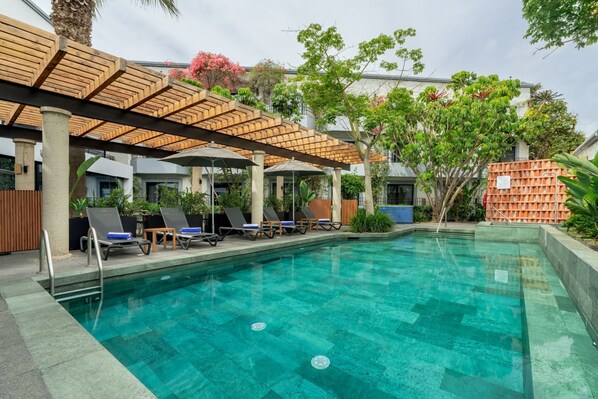 A swimming pool with lounge chairs and a pergola structure. - Hilton Garden Inn Tijuana Airport (Tijuana)