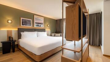 Habitación de hotel con una cama grande, televisión y obras de arte en la pared.