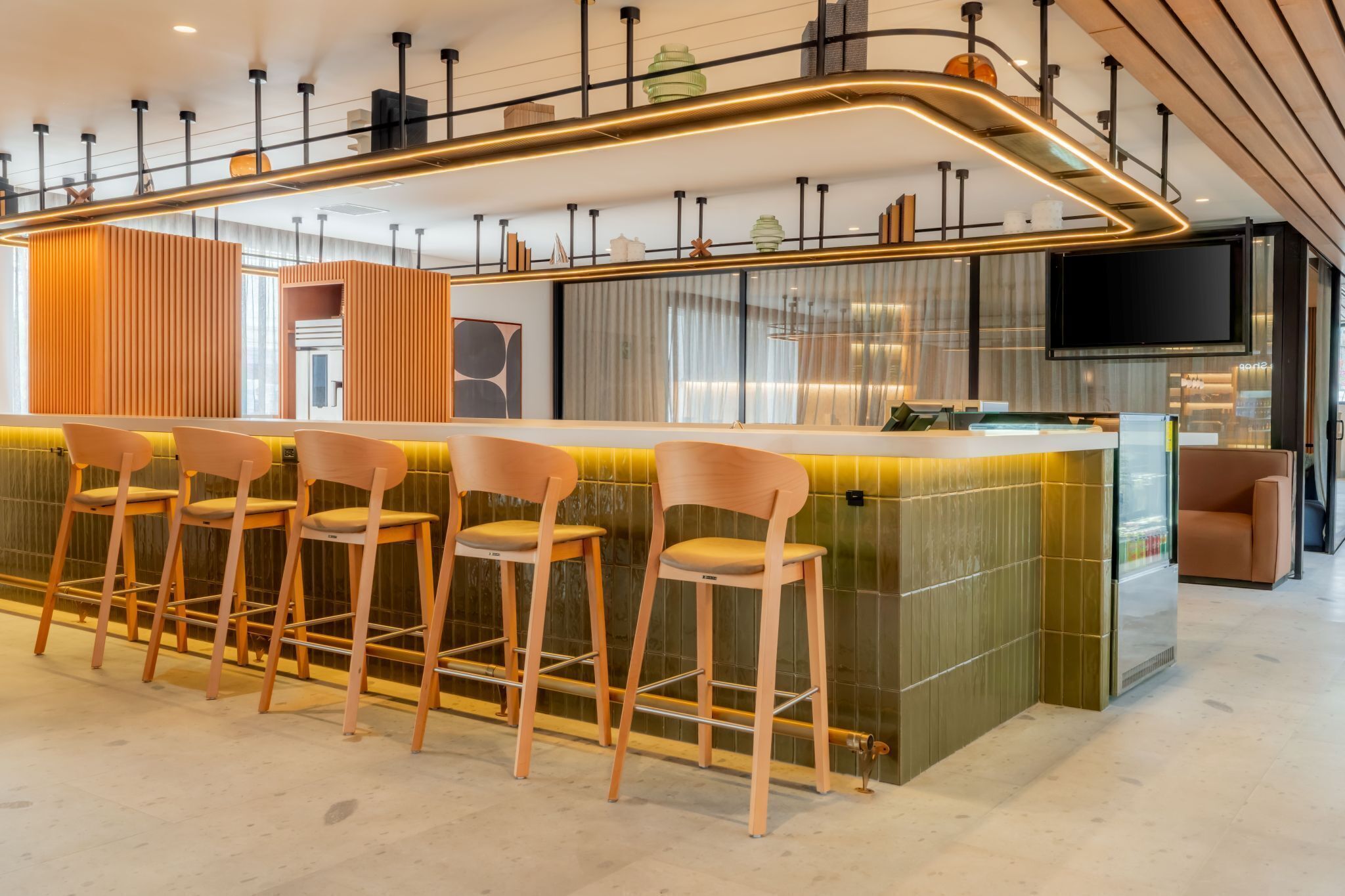 A modern bar area with a curved counter and multiple bar stools.