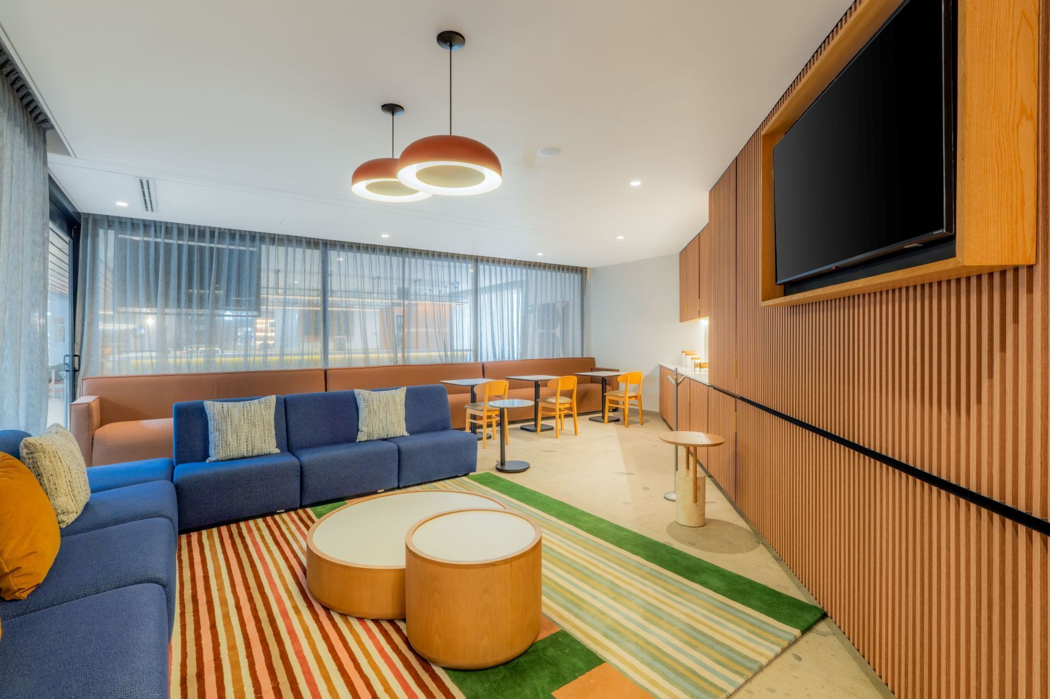 Una sala moderna con sofá, mesa de centro y pared de televisión.