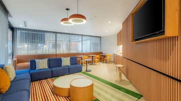 Una sala moderna con sofá, mesa de centro y pared de televisión.