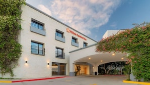 A building with a white facade, a visible entrance, and a sign reading 'Hilton Garden Inn'.