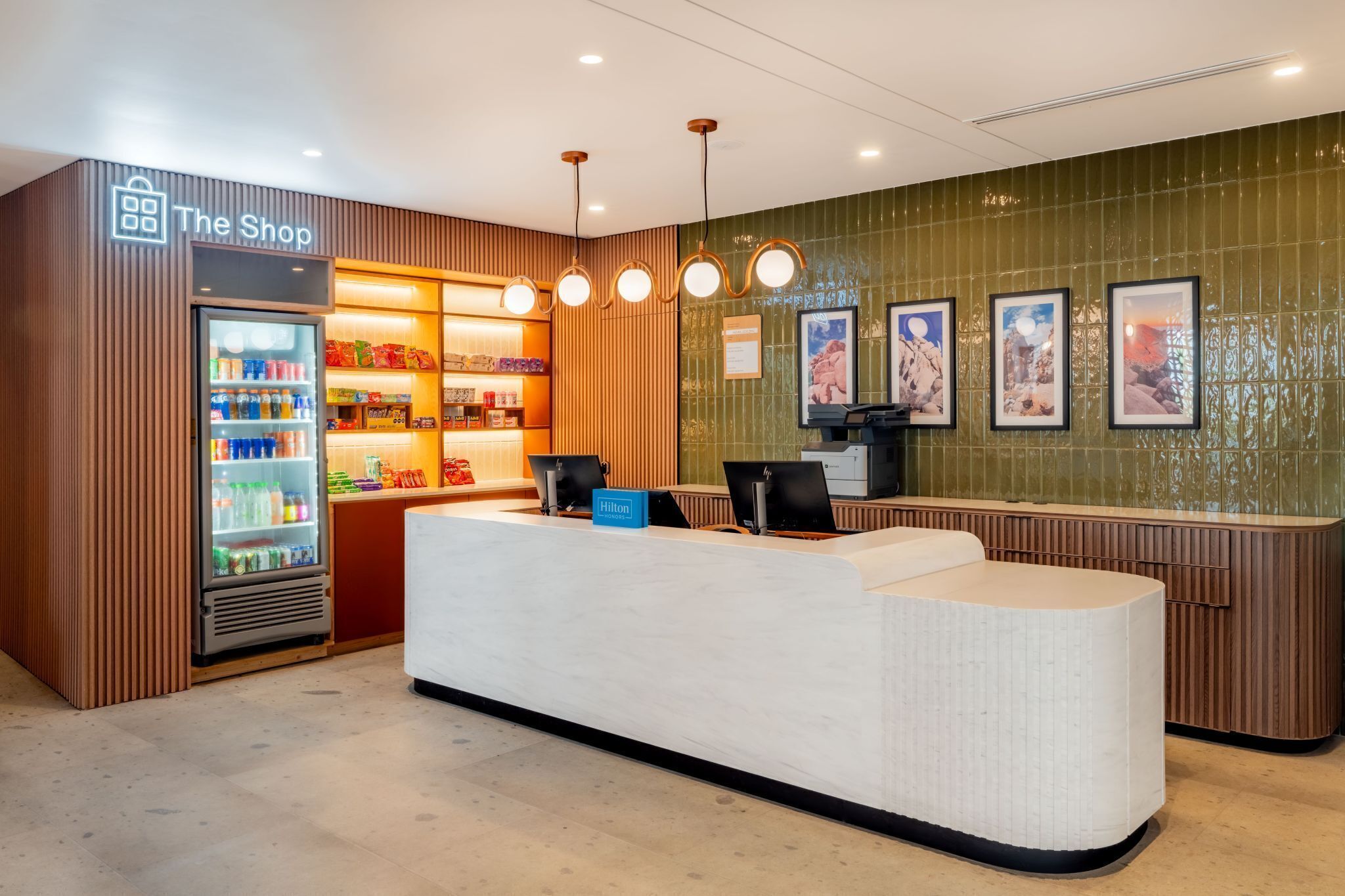 A hotel reception area with a counter, a minibar, and a refrigerator stocked with beverages.