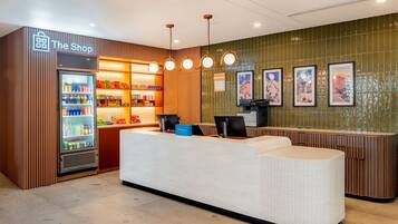 A hotel reception area with a counter, a minibar, and a refrigerator stocked with beverages.