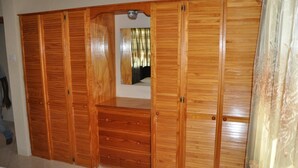 Ein Holzkleiderschrank mit mehreren Fächern und einem Spiegel.