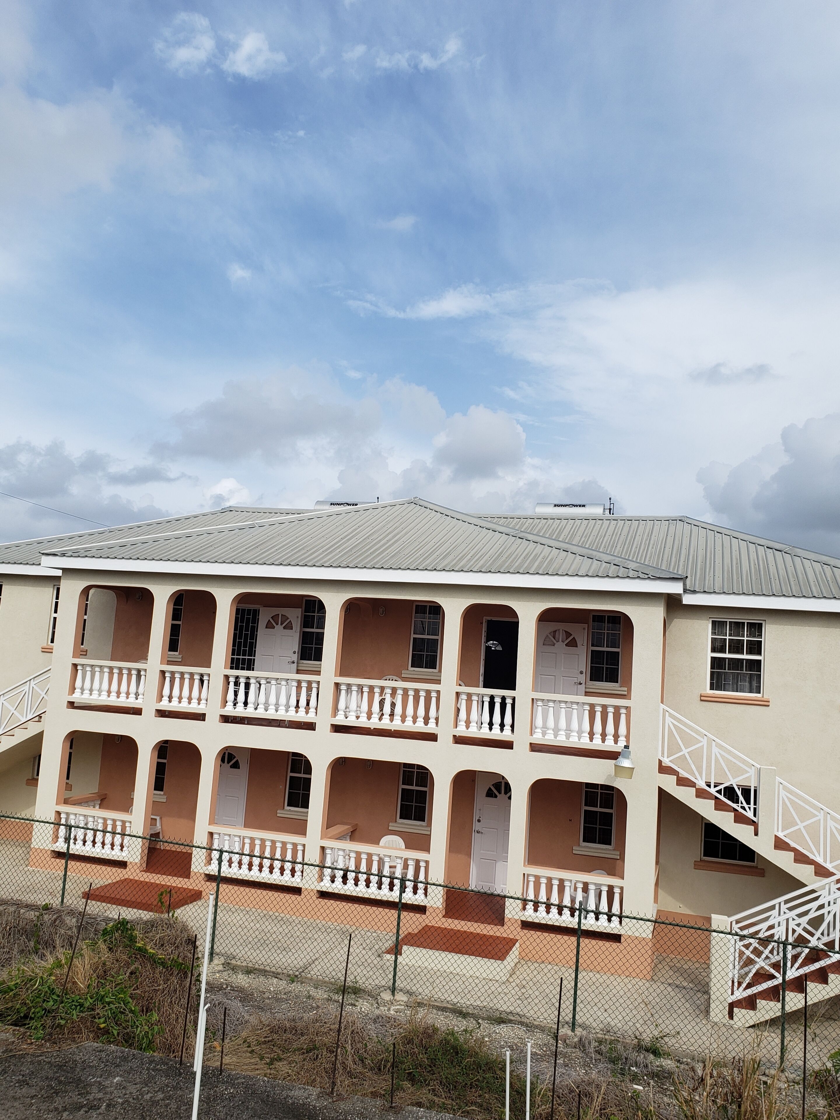 A multi-story building with balconies and a staircase.
