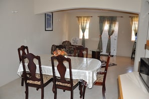 Un comedor con una mesa, sillas y un ventilador.