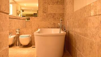 A bathroom with a bathtub, toilet, and bidet.