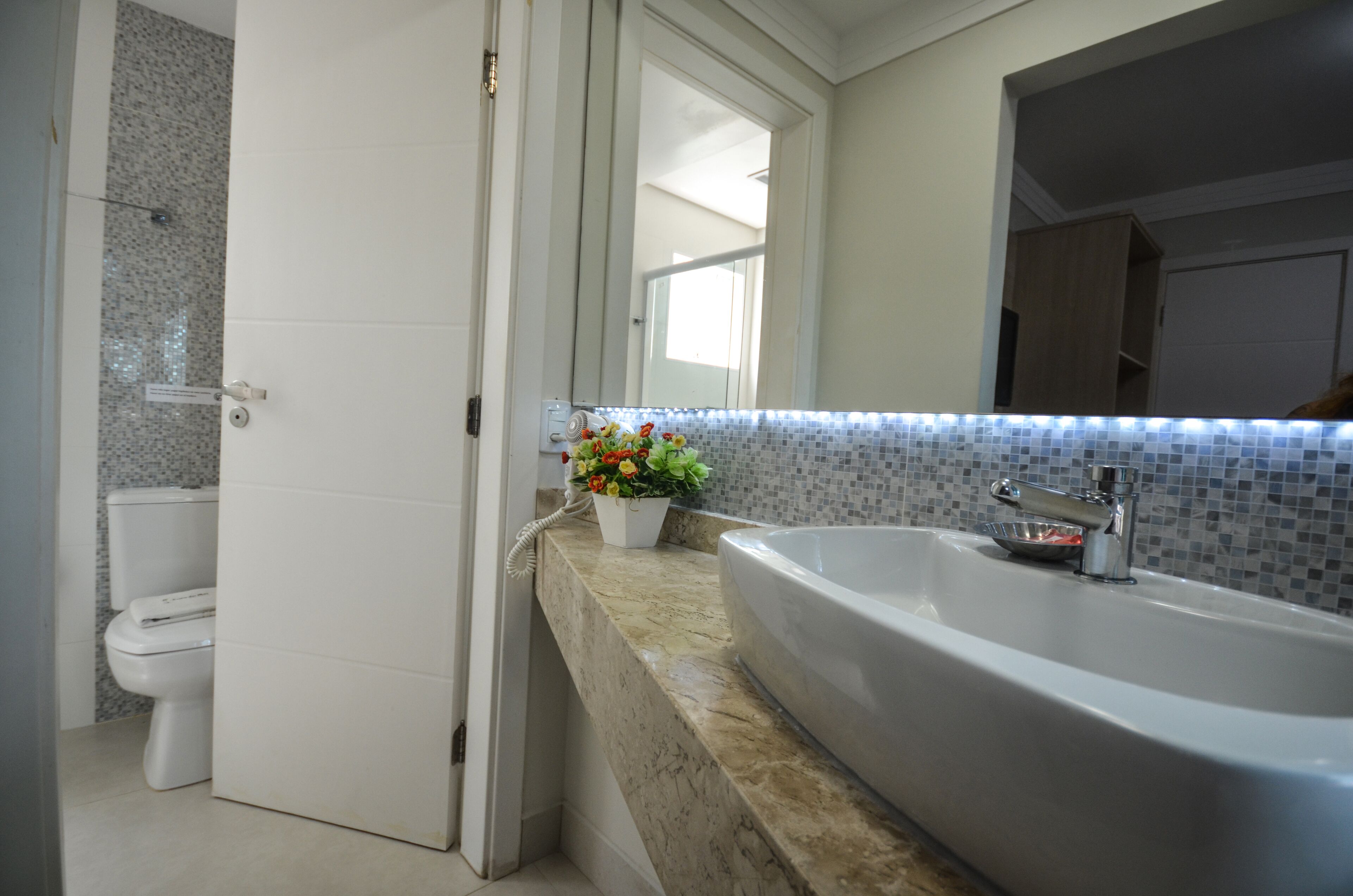 A bathroom with a white bathtub, a white toilet, and a tiled backsplash.