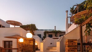 Una escalera que lleva a un edificio de paredes de piedra y fachada blanca.