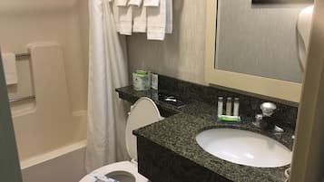 A bathroom with a toilet, sink, and shower.