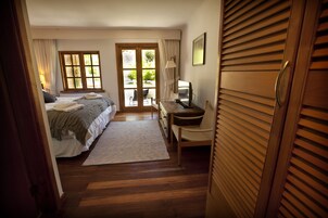 Un dormitorio con cama, escritorio, silla, lámpara y ventana.