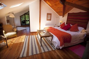 Une chambre à coucher avec un lit, une chaise, une table et une fenêtre.