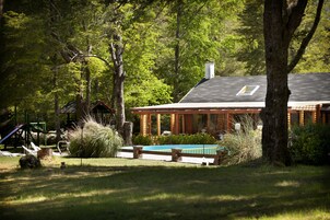 Una piscina al aire libre, sillones reclinables de piscina