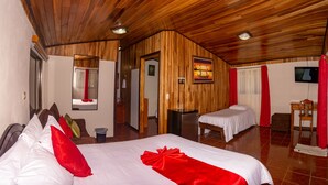 A hotel room with two beds, wooden ceiling, a TV, and a small table. - Mar Inn Bed & Breakfast (Monteverde)