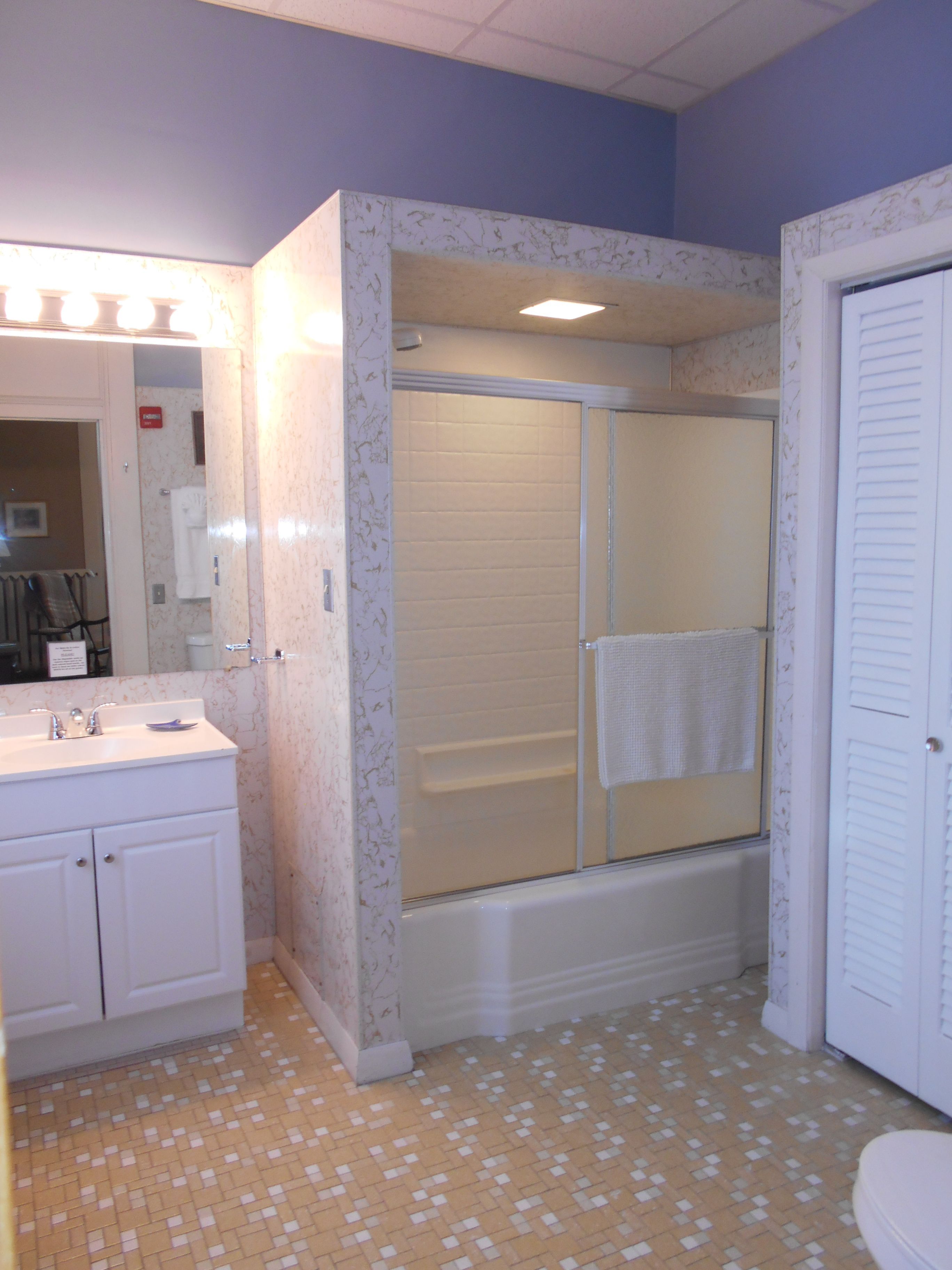 A bathroom with a shower, sink, and toilet.