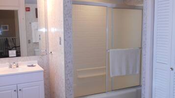 A bathroom with a shower, sink, and toilet.