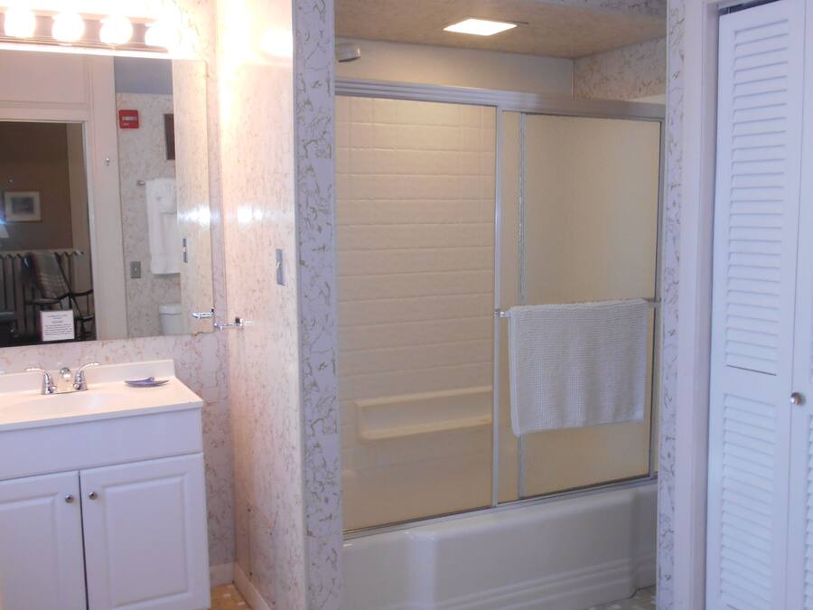 A bathroom with a shower, sink, and toilet.