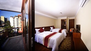 A hotel room with two beds, a balcony, and a city view. - Karma Hotel Nepal (Kathmandu)