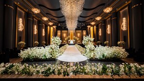 A grand hall with a central aisle, flanked by columns and floral arrangements, leading to a focal point at the end. - The Central Park Hotel Songdo (Incheon)