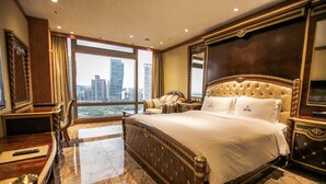 A spacious hotel room with a large bed, a desk, and a chair.