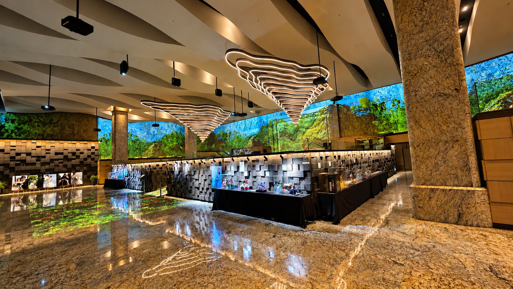 Um lobby moderno com um balcão de recepção extenso, uma grande tela digital exibindo uma paisagem natural e um design de teto singular.