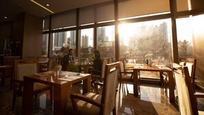 A modern restaurant with wooden furniture and large windows offering a city view.