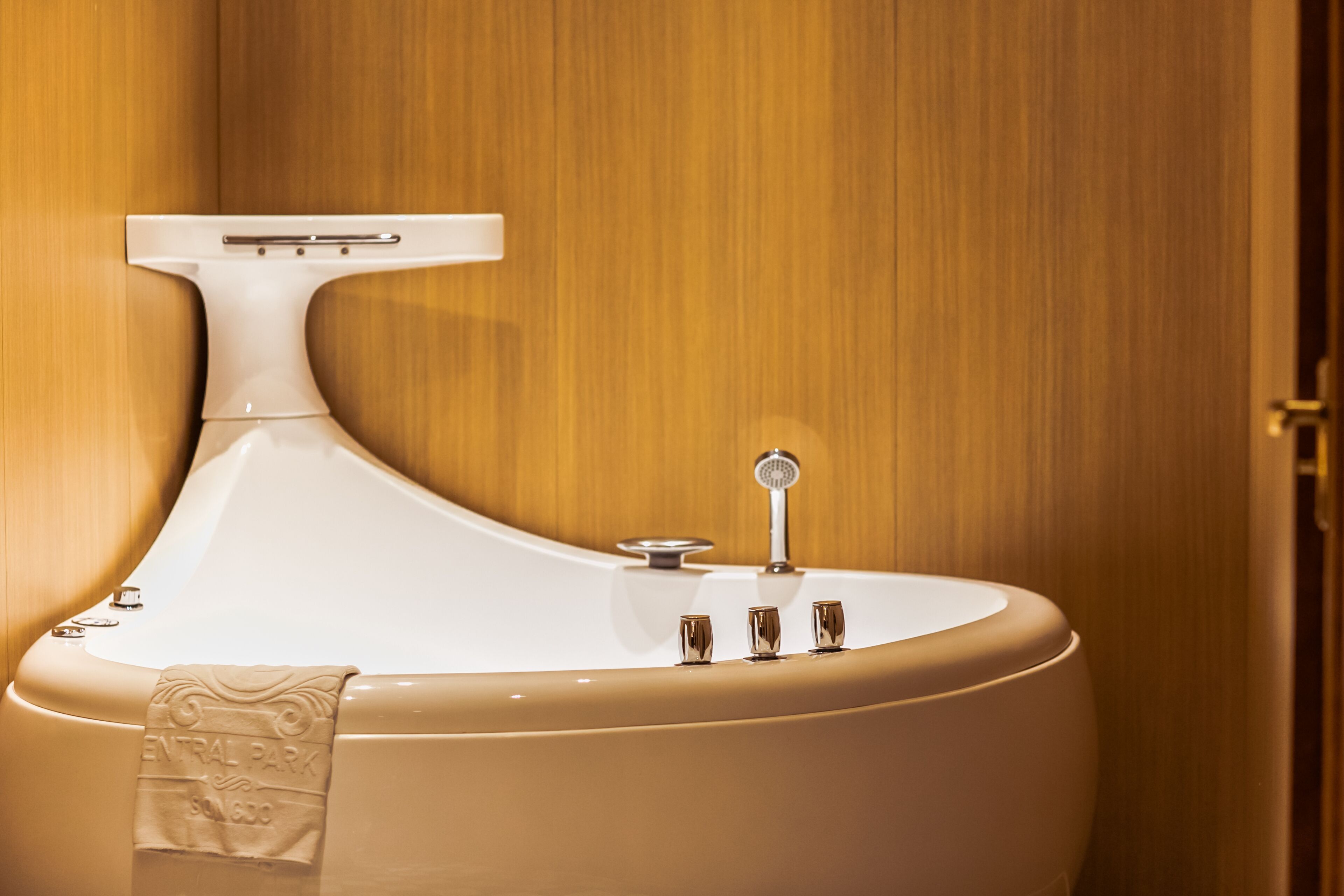 A modern bathroom with a freestanding bathtub, a towel rack, and a mirror.