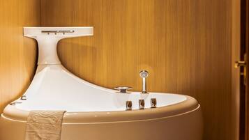 A modern bathroom with a freestanding bathtub, a towel rack, and a mirror.