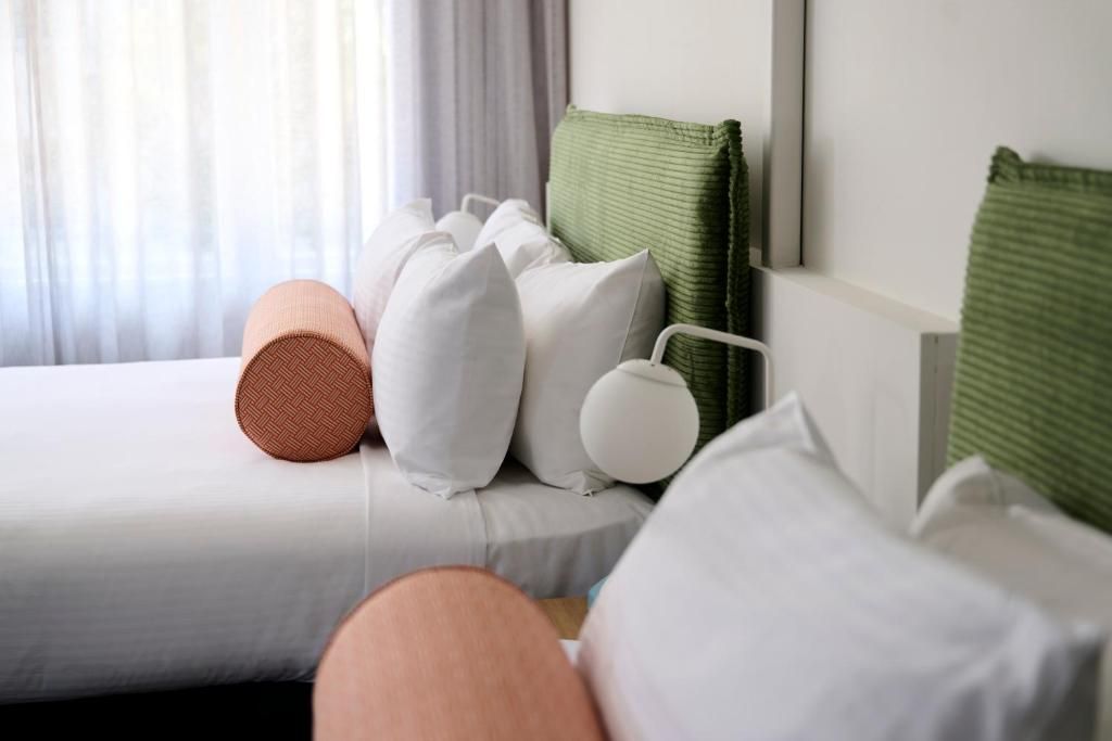 A bed with white bedding and multiple pillows.