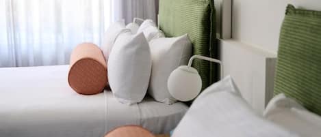A bed with white bedding and multiple pillows.