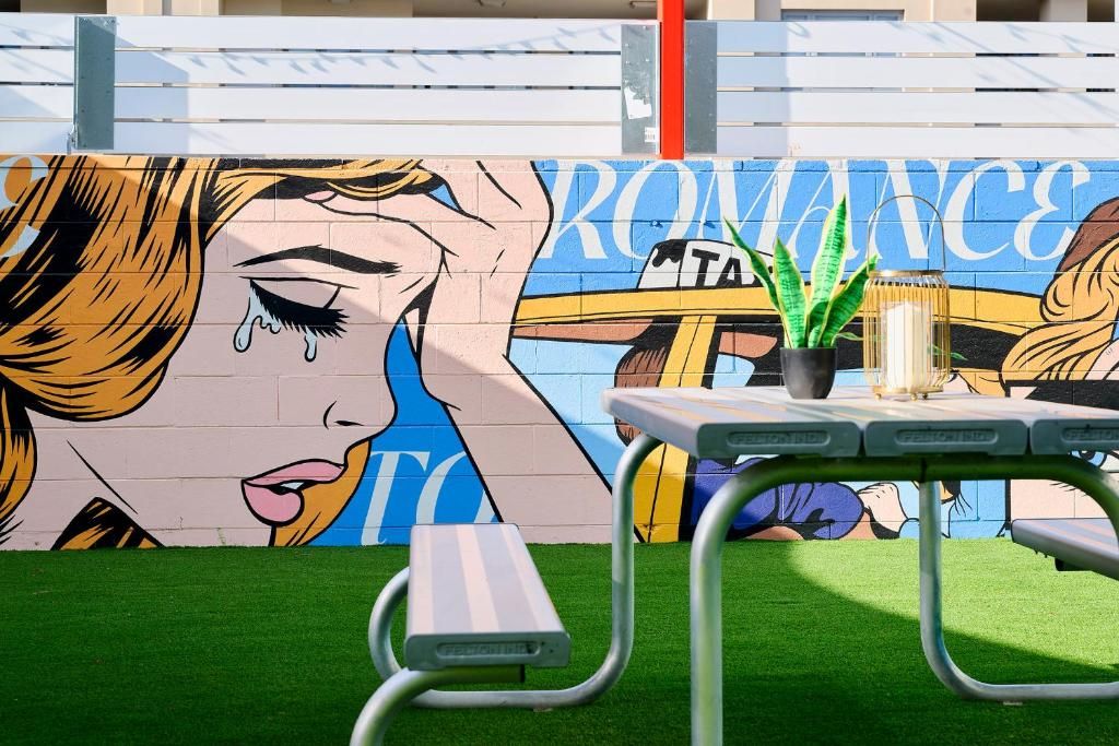 A mural with the word 'ROMANCE' and a table with a plant on it.