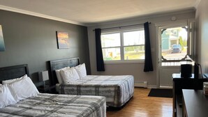 A hotel room with two beds, a desk, and a window with curtains. - Briarwood Coastal Cottages & Lodge (Union)