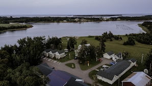 A lakeside property with multiple houses, a dock, and a grassy area. - Briarwood Coastal Cottages & Lodge (Union)