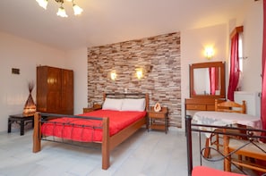 Une chambre à coucher avec un lit en bois, une table de chevet, une commode, un miroir et un mur au motif de briques.
