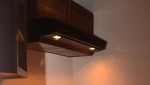 A kitchen with granite countertops, a stainless steel sink, wooden cabinets, and a range hood. - Bexon Rooms - Hotel Downtown Windsor (Windsor)