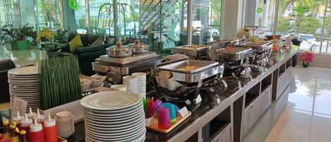 Montaje de bufé con distintas estaciones de comida, platos y salsas.