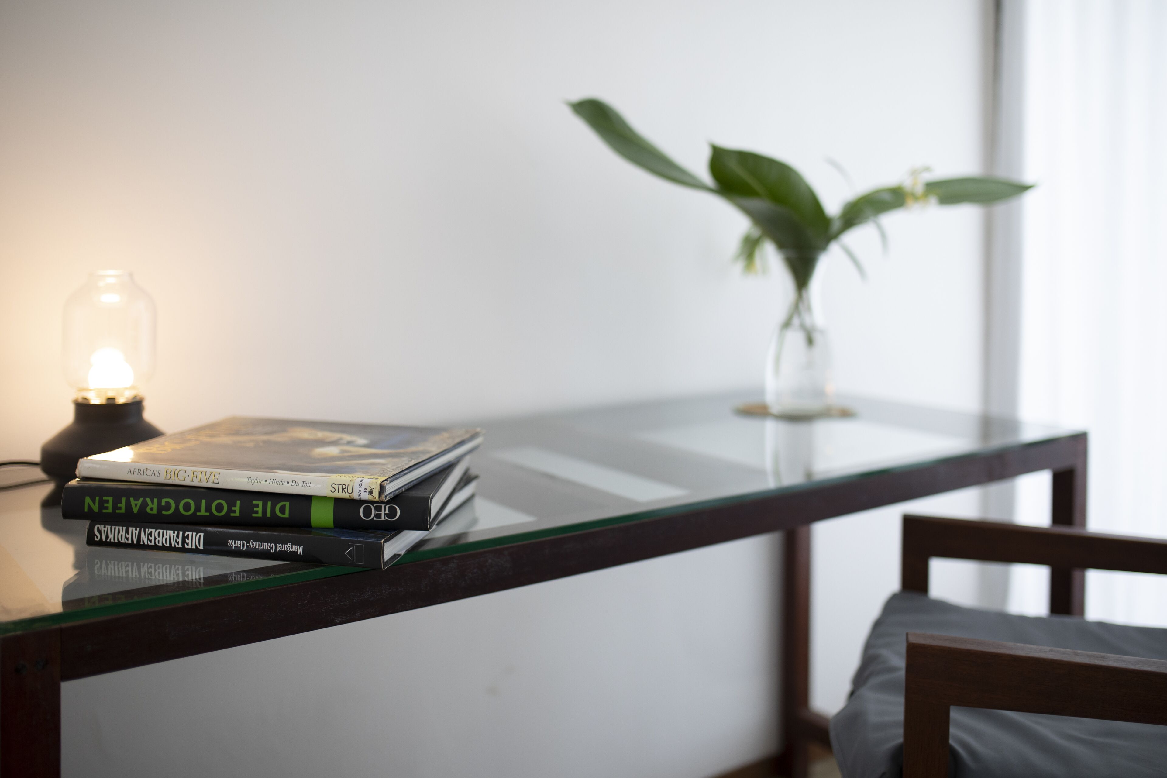 A glass table with books and a candle.