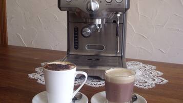 Eine Kaffeemaschine mit zwei Tassen Kaffee auf einem Holztisch.