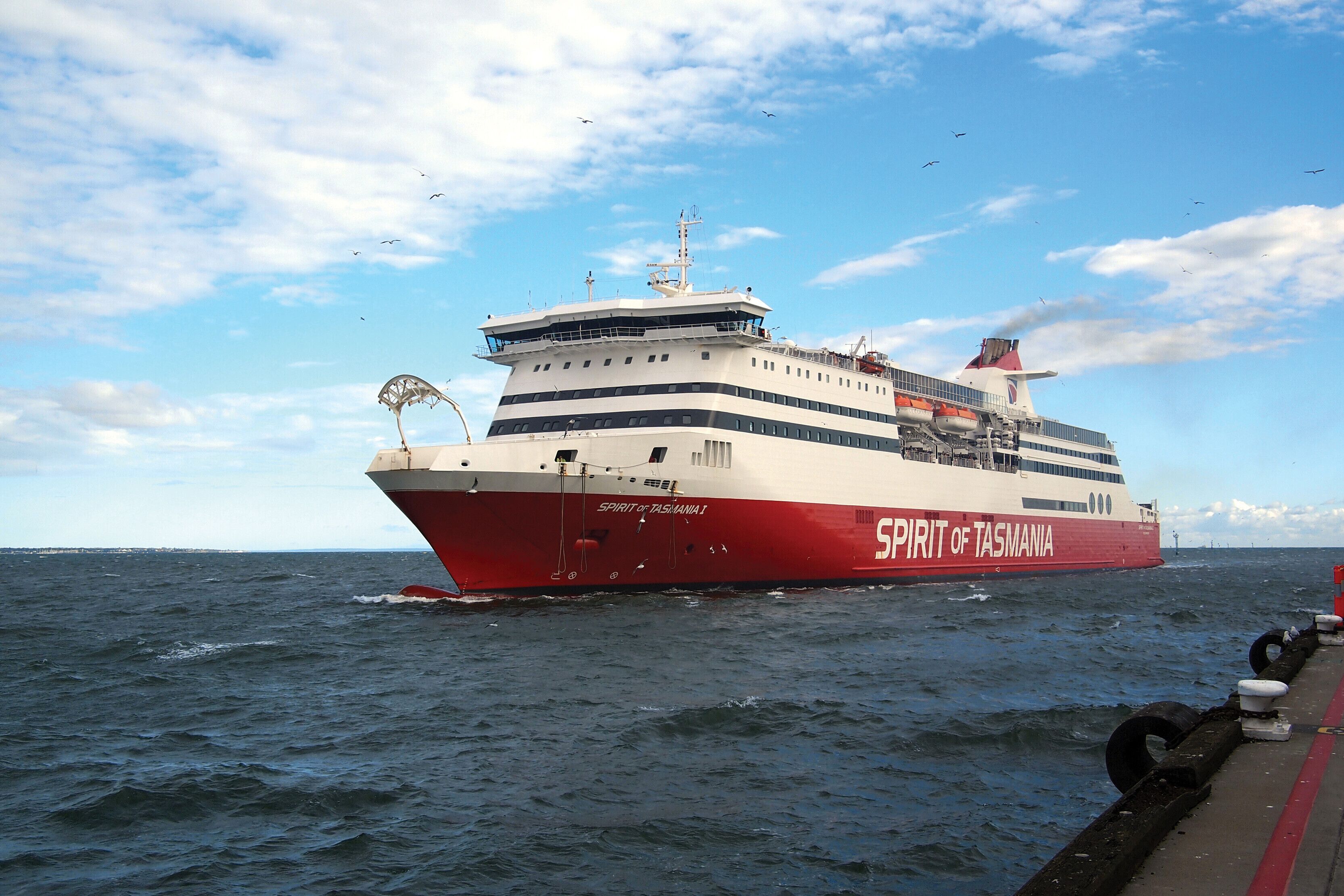 Un grand navire de croisière nommé « Spirit of Tasmania », doté de nombreux ponts et d’une cheminée imposante, navigue sur une étendue d’eau.